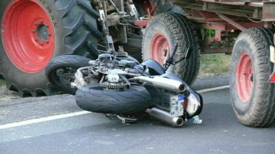 Motorradfahrer fährt in Traktor-Anhänger